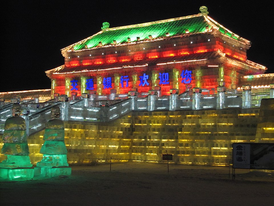 An illuminated building in a traditional Chinese style architecture made of ice blocks